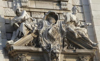 Closeup of seated figures flanking a shield