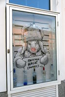 Rabbit in russian hat, wearing gloves, holding sign in pseudo-Russian for vodka
