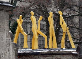 Wooden sculptures of walking people on rooftop