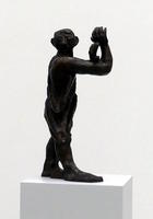 Man with hands in front of him, head turned toward viewer