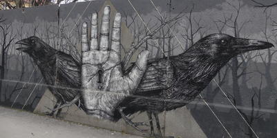 Two crows on either side of a hand facing palm outward, keyhole in palm of hand.