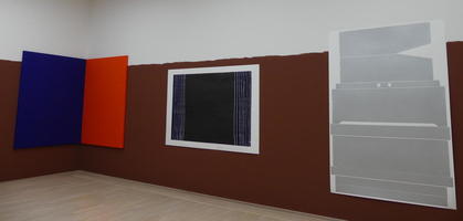 Abstracts in room with wall painted brown from floor halfway to ceiling.