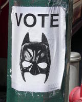 Poster: VOTE with a batman cowl beneath it