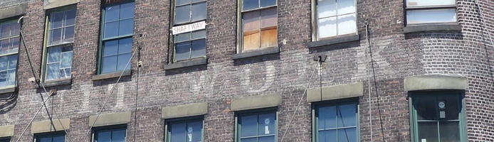 Faded paint on brick; last part “...WORKS” legible