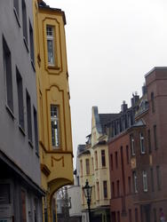 Street in residential area; yellow house in front left.