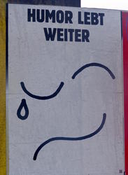 Half-smiling, half-crying line drawing of eyes and mouth with text “Humor lives on”.