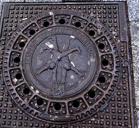 Manhole cover showing boys doing cartwheels.