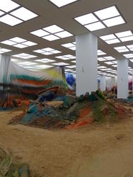 Colored dirt and painted curtains hung from ceiling