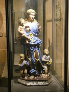 Woman representing charity, dressed in blue, holding baby.