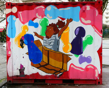 boy in cardboard box surrounded by large game pieces