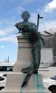 woman reaching up to bust of person