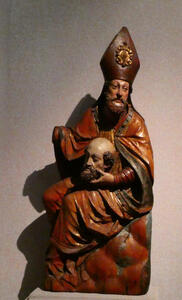 man in bishops mitre holding head of beheaded man in lap