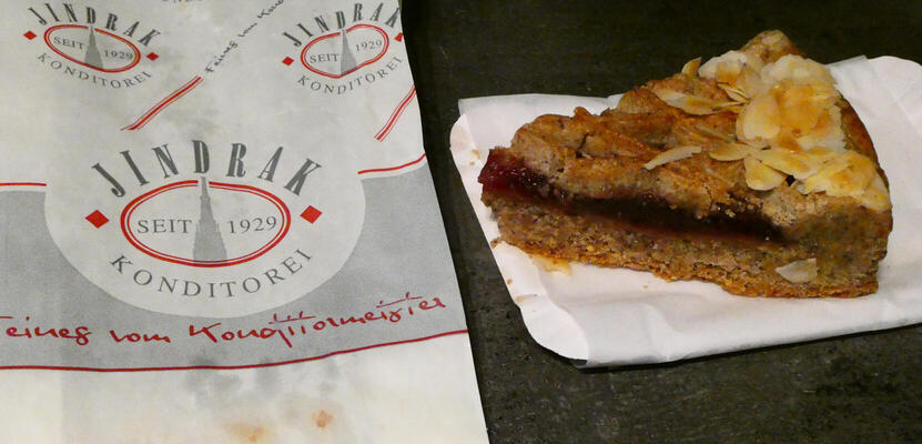 slice of linzer torte next to bag from konditorei