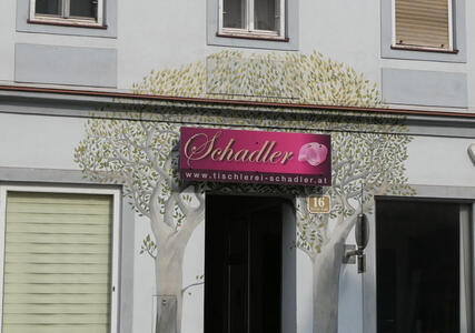 Trees painted on walls separated by a door.