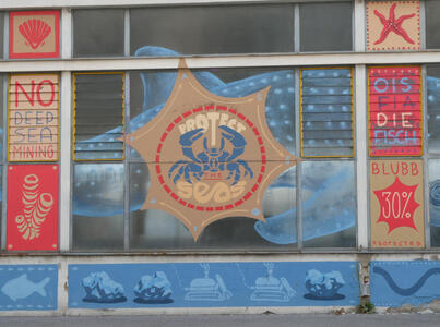 Crab in a 7-pointed star-shaped shield. Text: Protect the Seas. At left, text: No deep sea mining