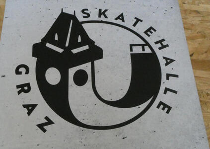 Texxt: Skatehalle Graz; image of Uhrturm with a skateboard ramp extending to its right