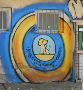 Cartoonish beagle with yellow ears, sitting up and looking to right. It inside concentric blue and yellow rings.