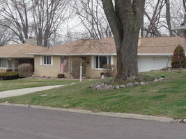 Beige brick house with flag in front