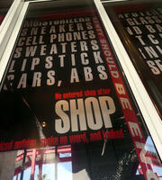 Large poster with words: sneakers cell phones sweaters lipstick SHOP