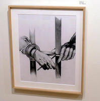 Closeup of hands in handcuffs behind bars, holding pencil in one hand