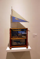 Wooden case with sailing flag on top, ship in imddle, and shark in bottom part of case