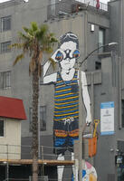 Wall art of small boy holding sand pail and looking through binoculars