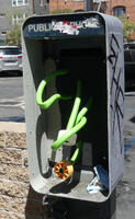 Public telephone with exposed green cables and yellow connector