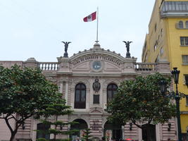 Gray building with arch and winged figures at either side