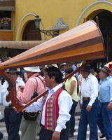 Man carrying large stringed instrument with wooden cone-shaped base