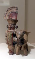 Man with headdress standing next to animal