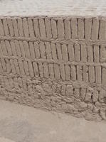 Wall with original, damaged bricks at bottom and pristine replicas above.