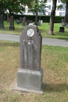 Weathered headstone with small circular carving at top