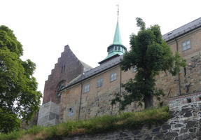 Yellow brick building in foreground, church spire in background