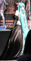 Woman in flowing black dress and long turquoise hair
