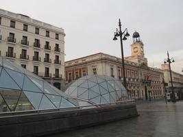 Modern subway entrance in foreground; old building in backgound.