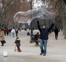 Man using large hoops to create giant soap bubbles