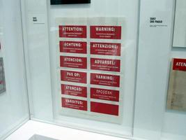 Red stickers in multiple languages reading “Warning: Perception requires engagement.”