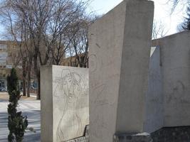 Sculpture made of slabs of stone, with picasso-like drawings etched on them.