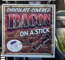 sign for chocolate covered bacon on a stick