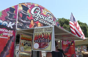 Sign for chocolate covered bacon on a stick.