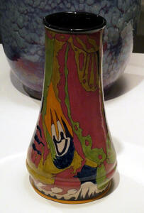 Vase with primarily dark red, green, and orange abstract pattern
