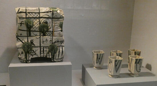 At left, two-tired box with green decoration; at right, five square Japanese style tea cups