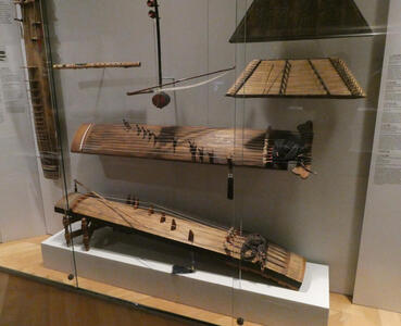 Asian stringed instruments with flat bottom, curved top, and strings aligned with long axis of the body.