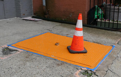 Cellar door painted bright orange, with orange traffic cone on top