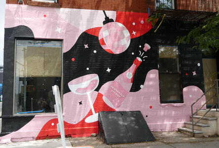 Pink and red wall mural showing disco ball champagne glass, and champagne bottle
