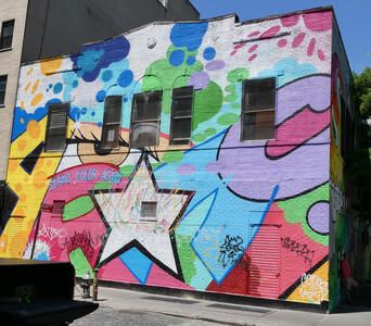Wall painting with multi-colored geometric shapes and white star in middle