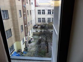 Dilapidated buildings and trash strewn behind hotel