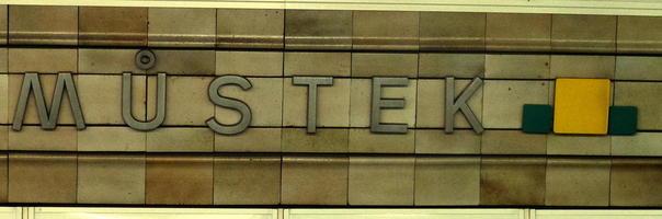 Můstek subway sign; at right are short green bars surrounding a longer green bar.