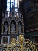 Three arches with religious figure statues, gold railing in front