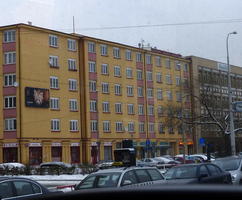 Office/apartment building painted yellow, with some rust-colored vertical stripes